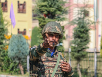 An Indian paramilitary soldier stands guard as polling officials carry electronic voting machines (EVM) at a distribution center in the Sumb...