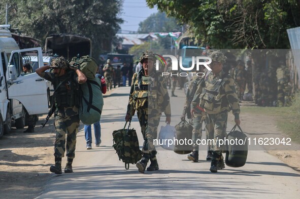 An Indian paramilitary soldier walks outside a distribution center in the Sumbal area of Bandipora district, north of Srinagar, on September...