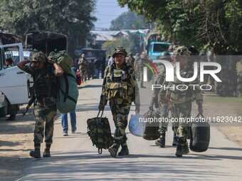 An Indian paramilitary soldier walks outside a distribution center in the Sumbal area of Bandipora district, north of Srinagar, on September...