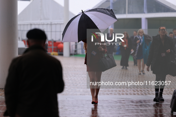 Delegates arrive in the pouring rain to the Conservative Party Conference at the International Conference Centre in Birmingham, United Kingd...