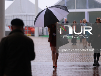 Delegates arrive in the pouring rain to the Conservative Party Conference at the International Conference Centre in Birmingham, United Kingd...