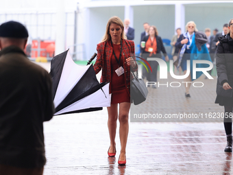 Delegates arrive in the pouring rain to the Conservative Party Conference at the International Conference Centre in Birmingham, United Kingd...