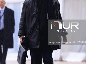 Delegates arrive in the pouring rain to the Conservative Party Conference at the International Conference Centre in Birmingham, United Kingd...