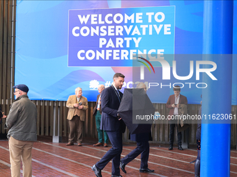 Delegates arrive in the pouring rain to the Conservative Party Conference at the International Conference Centre in Birmingham, United Kingd...