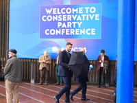 Delegates arrive in the pouring rain to the Conservative Party Conference at the International Conference Centre in Birmingham, United Kingd...