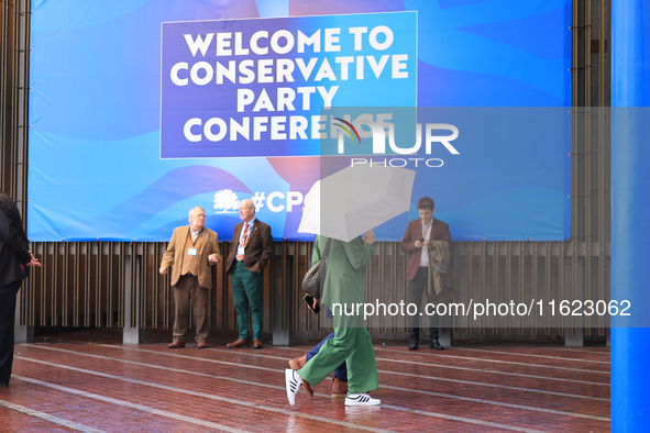 Delegates arrive in the pouring rain to the Conservative Party Conference at the International Conference Centre in Birmingham, United Kingd...