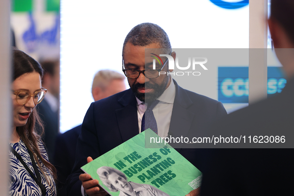 James Cleverly MP carries a Maggie Thatcher placard at the Conservative Party Conference at the International Conference Centre in Birmingha...