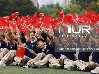 More than 7,000 teachers and students of Hongxiang Education Group sing and dance to celebrate National Day in Sihong County, Suqian, China,...