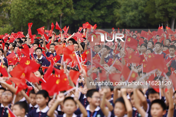 More than 7,000 teachers and students of Hongxiang Education Group sing and dance to celebrate National Day in Sihong County, Suqian, China,...