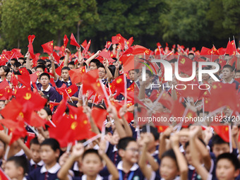 More than 7,000 teachers and students of Hongxiang Education Group sing and dance to celebrate National Day in Sihong County, Suqian, China,...