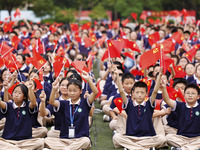 More than 7,000 teachers and students of Hongxiang Education Group sing and dance to celebrate National Day in Sihong County, Suqian, China,...