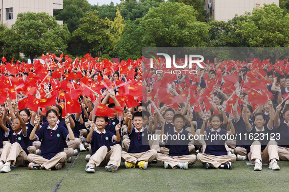 More than 7,000 teachers and students of Hongxiang Education Group sing and dance to celebrate National Day in Sihong County, Suqian, China,...