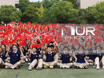 More than 7,000 teachers and students of Hongxiang Education Group sing and dance to celebrate National Day in Sihong County, Suqian, China,...