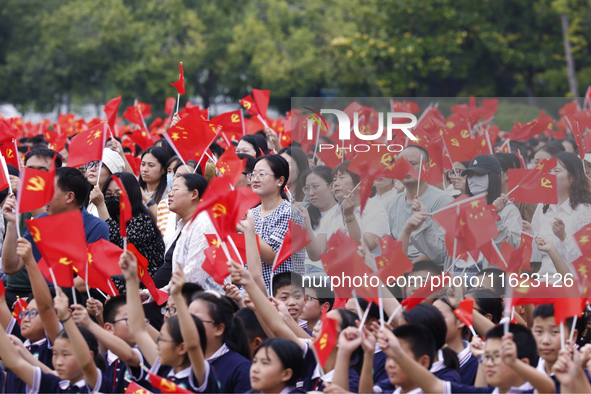 More than 7,000 teachers and students of Hongxiang Education Group sing and dance to celebrate National Day in Sihong County, Suqian, China,...