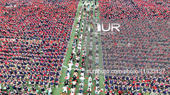 More than 7,000 teachers and students of Hongxiang Education Group sing and dance to celebrate National Day in Sihong County, Suqian, China,...