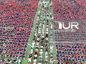 More than 7,000 teachers and students of Hongxiang Education Group sing and dance to celebrate National Day in Sihong County, Suqian, China,...