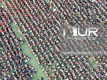 More than 7,000 teachers and students of Hongxiang Education Group sing and dance to celebrate National Day in Sihong County, Suqian, China,...