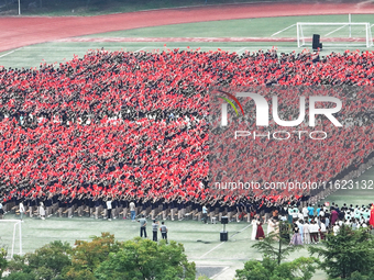 More than 7,000 teachers and students of Hongxiang Education Group sing and dance to celebrate National Day in Sihong County, Suqian, China,...