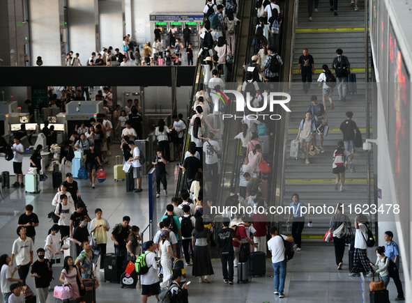 Passengers enter a waiting room after checking their tickets at Nanchang Railway Station in Nanchang, China, on September 30, 2024. 