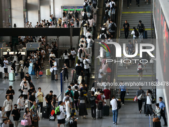 Passengers enter a waiting room after checking their tickets at Nanchang Railway Station in Nanchang, China, on September 30, 2024. (