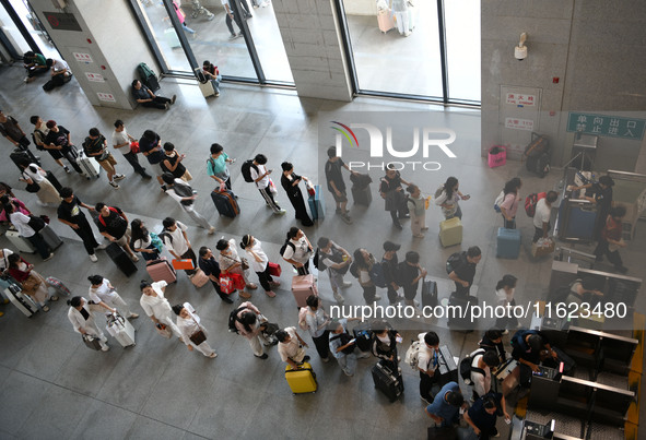 Passengers enter a waiting room after checking their tickets at Nanchang Railway Station in Nanchang, China, on September 30, 2024. 