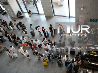 Passengers enter a waiting room after checking their tickets at Nanchang Railway Station in Nanchang, China, on September 30, 2024. (