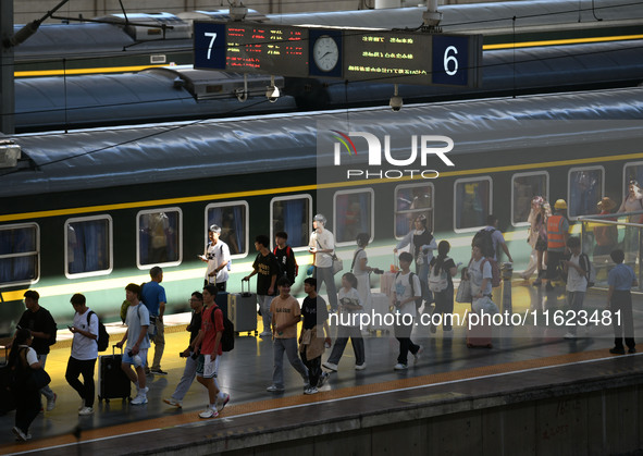 Passengers get on and off a train at Nanchang Railway Station in Nanchang, China, on September 30, 2024. 