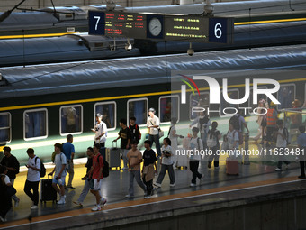 Passengers get on and off a train at Nanchang Railway Station in Nanchang, China, on September 30, 2024. (