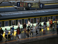 Passengers get on and off a train at Nanchang Railway Station in Nanchang, China, on September 30, 2024. (