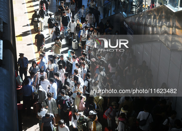 Passengers get on and off a train at Nanchang Railway Station in Nanchang, China, on September 30, 2024. 