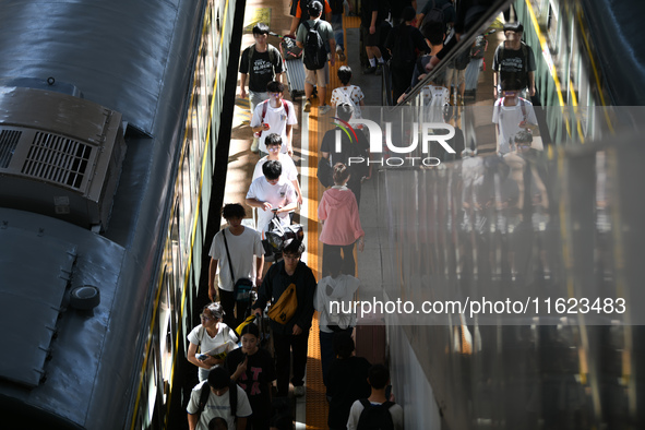 Passengers get on and off a train at Nanchang Railway Station in Nanchang, China, on September 30, 2024. 