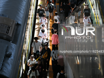 Passengers get on and off a train at Nanchang Railway Station in Nanchang, China, on September 30, 2024. (