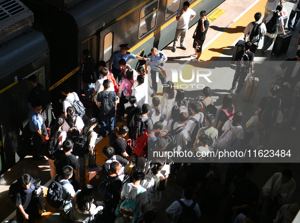 Passengers get on and off a train at Nanchang Railway Station in Nanchang, China, on September 30, 2024. 