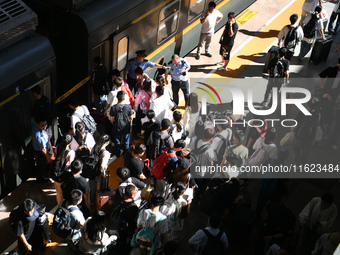 Passengers get on and off a train at Nanchang Railway Station in Nanchang, China, on September 30, 2024. (