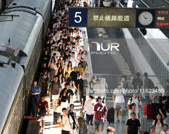 Passengers get on and off a train at Nanchang Railway Station in Nanchang, China, on September 30, 2024. 