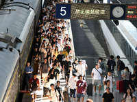 Passengers get on and off a train at Nanchang Railway Station in Nanchang, China, on September 30, 2024. (