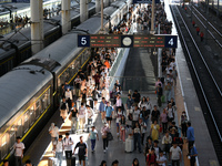 Passengers get on and off a train at Nanchang Railway Station in Nanchang, China, on September 30, 2024. (