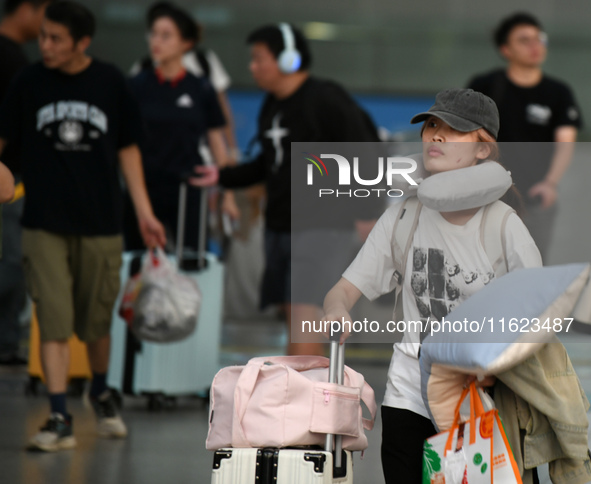 Passengers get on and off a train at Nanchang Railway Station in Nanchang, China, on September 30, 2024. 