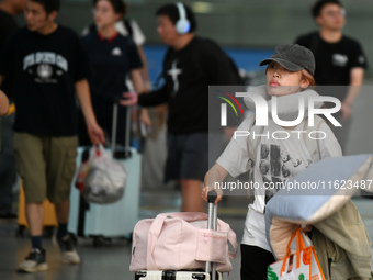 Passengers get on and off a train at Nanchang Railway Station in Nanchang, China, on September 30, 2024. (