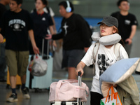 Passengers get on and off a train at Nanchang Railway Station in Nanchang, China, on September 30, 2024. (