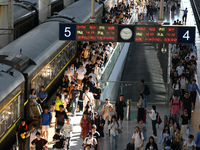 Passengers get on and off a train at Nanchang Railway Station in Nanchang, China, on September 30, 2024. (