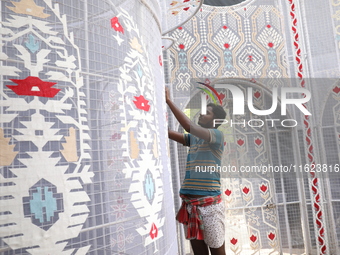 A weaver makes a Jamdani design on a cloth to decorate a ''pandal'' or a temporary platform ahead of the Durga Puja festival in Kolkata, Ind...