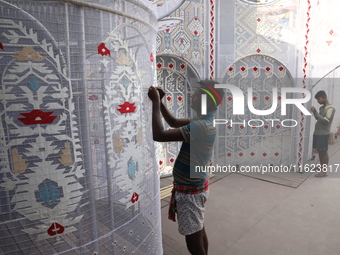 Weavers make Jamdani designs on cloth to decorate a ''pandal'' or temporary platform ahead of the Durga Puja festival in Kolkata, India, on...