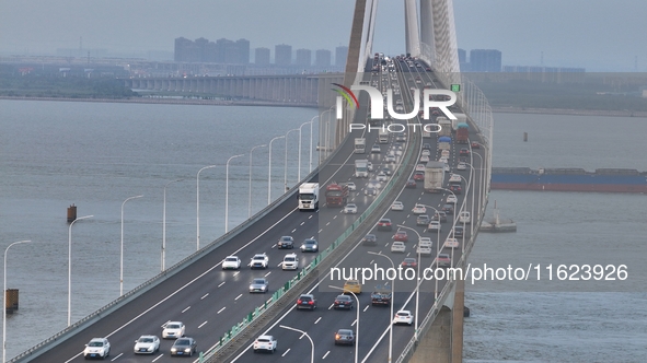 Traffic flows for several kilometers past the G15 Shenyang-Haikou Expressway of the Sutong Yangtze River Bridge in Changshu, China, on Septe...