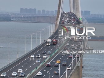 Traffic flows for several kilometers past the G15 Shenyang-Haikou Expressway of the Sutong Yangtze River Bridge in Changshu, China, on Septe...