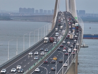 Traffic flows for several kilometers past the G15 Shenyang-Haikou Expressway of the Sutong Yangtze River Bridge in Changshu, China, on Septe...