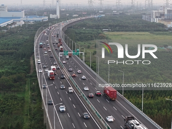 Traffic flows for several kilometers past the G15 Shenyang-Haikou Expressway of the Sutong Yangtze River Bridge in Changshu, China, on Septe...