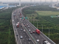 Traffic flows for several kilometers past the G15 Shenyang-Haikou Expressway of the Sutong Yangtze River Bridge in Changshu, China, on Septe...