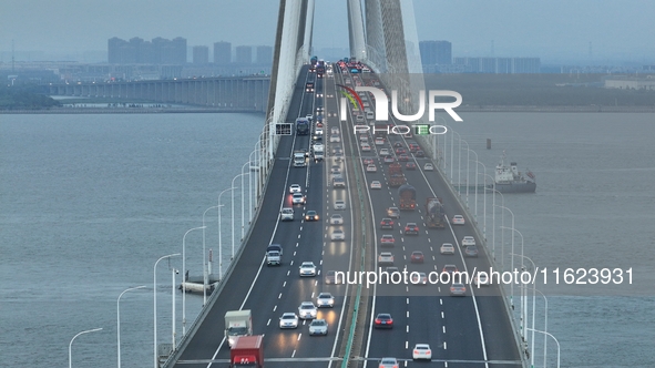 Traffic flows for several kilometers past the G15 Shenyang-Haikou Expressway of the Sutong Yangtze River Bridge in Changshu, China, on Septe...