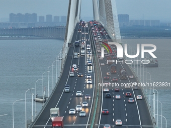 Traffic flows for several kilometers past the G15 Shenyang-Haikou Expressway of the Sutong Yangtze River Bridge in Changshu, China, on Septe...